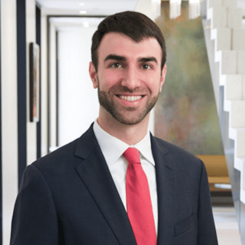Photo of Aaron Scherzer, Senior Counsel in dark blue suit and red tie.